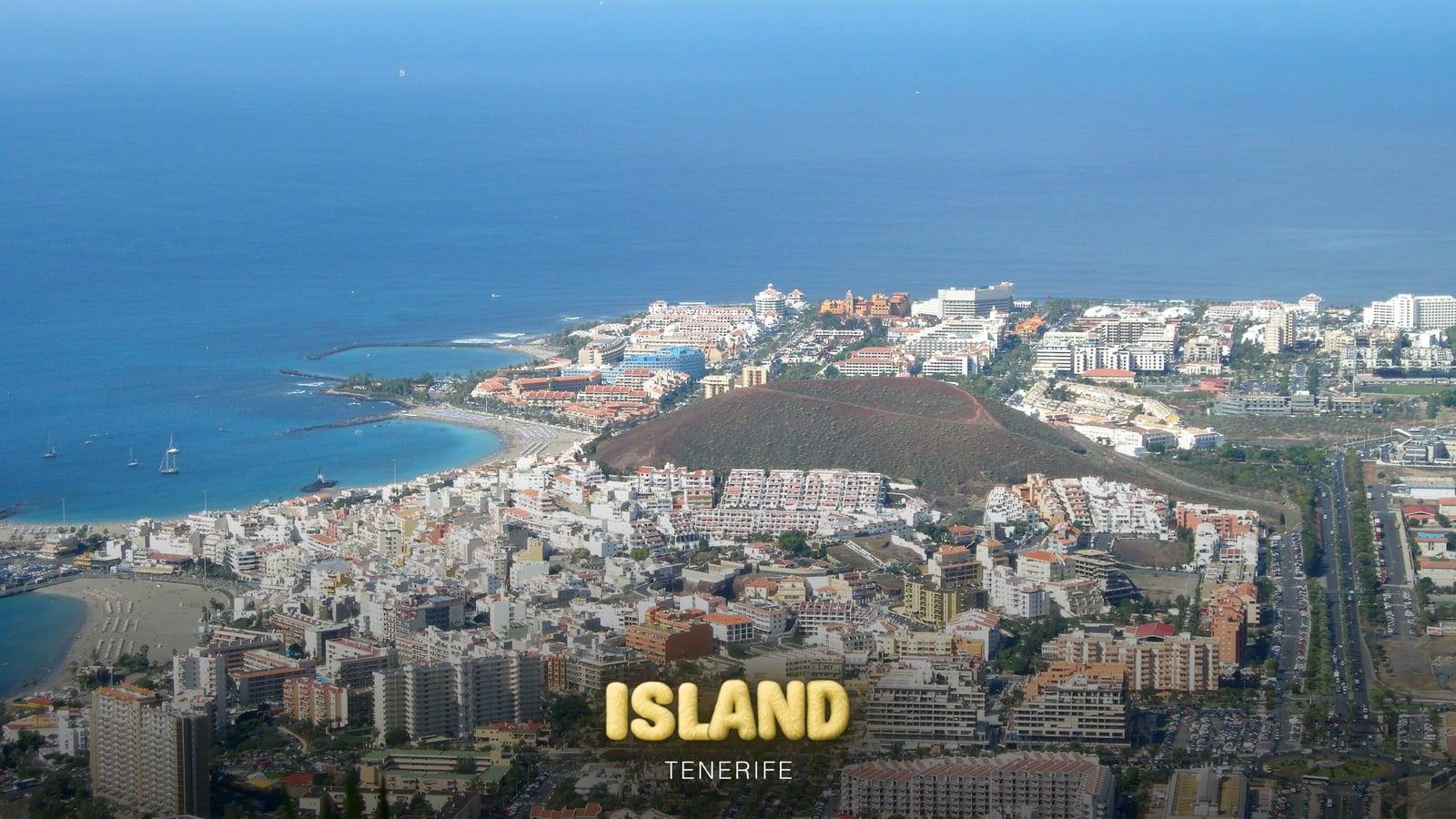 Los Cristianos and Playa de las Américas seen from Montaña de Guaza, Tenerife, with the Party Island Tenerife logo
